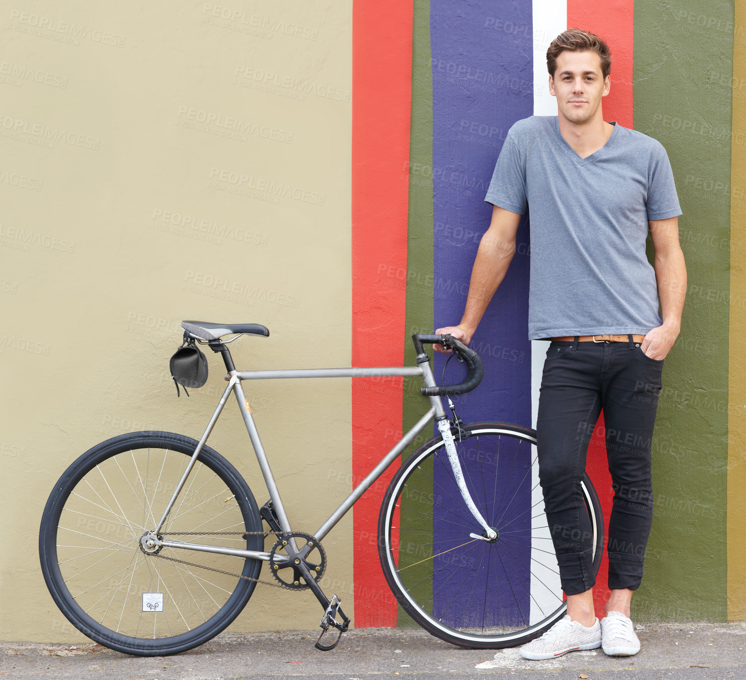 Buy stock photo Shot of a stylish young man standing outside with his bicycle