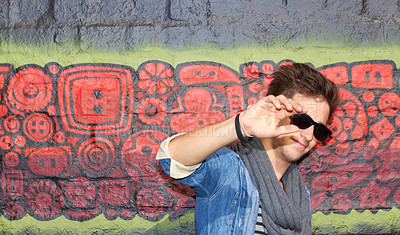 Buy stock photo Man, fashion and street style with graffiti, cool and outdoor in urban area, sunglasses or hand. Fashionable, wall or trendy with clothes, casual or styling in amsterdam, edgy and art background 