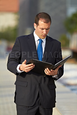 Buy stock photo A businessman looking through his diary at his schedule