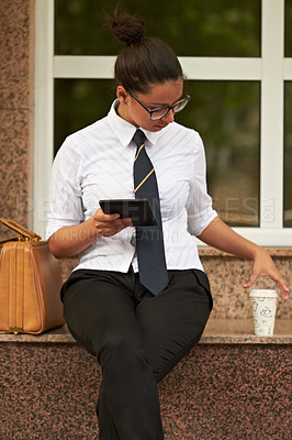 Buy stock photo A beautiful young woman sitting with her digital tablet and reaching for her coffee
