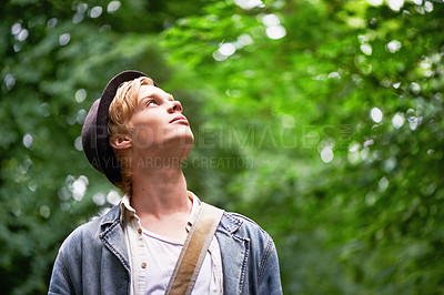 Buy stock photo A young man takes in his surroundings while hiking in a forest