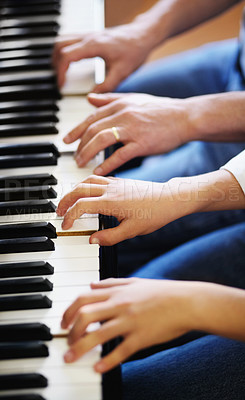 Buy stock photo Young boy playing the piano diligently alongside his tutor - cropped