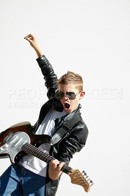 Buy stock photo Little boy playing the electric guitar with a rockstar attitude