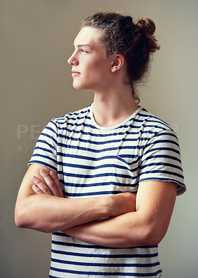 Buy stock photo Profile shot of a young man with his hair in a bun looking away