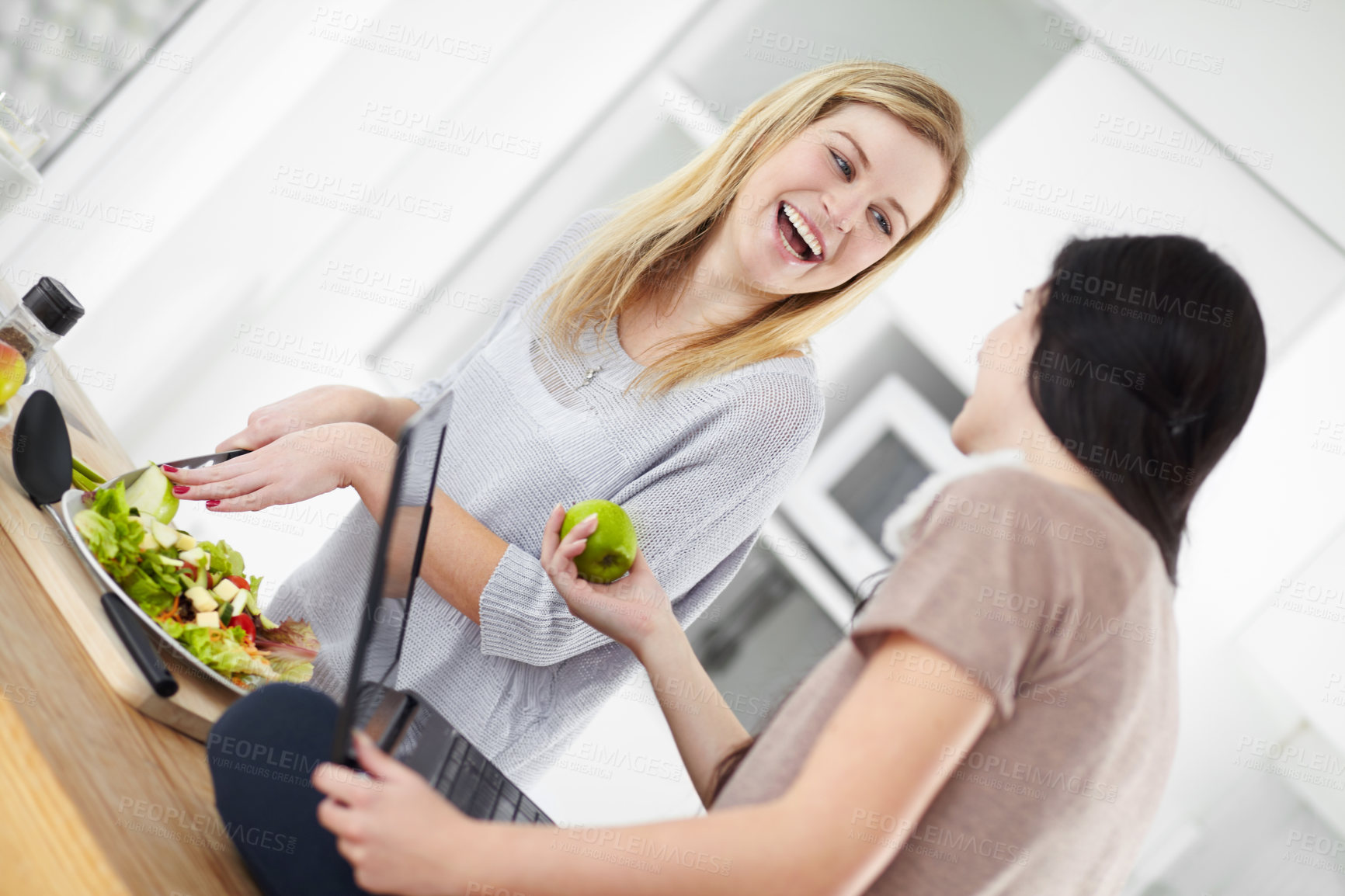 Buy stock photo Two young woman making a salad in the kitchen at home