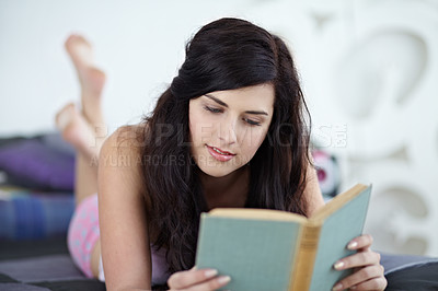 Buy stock photo Student, book and girl relax in bed reading a novel, chilling and resting in her home on the weekend. Textbook, learning and female student studying in a bedroom, content and calm with homework