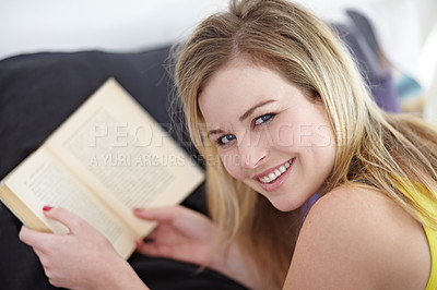 Buy stock photo Portrait, book and woman relax on a bed with a novel, happy and enjoying a day off in her home. Face, smile and female student with a textbook in a bedroom for studying, reading and leisure hobby