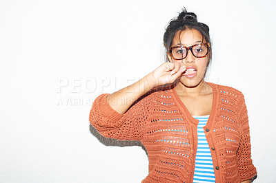 Buy stock photo Studio background, portrait and a flirty woman biting finger for fashion, streetwear or urban culture. Model, glasses and a young girl or person with mockup, flirting or stylish on a backdrop