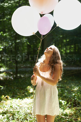 Buy stock photo Woman, holding balloons and peace in nature, playful and outdoors in forest, party decor and celebrate for freedom. Female person, sunshine and birthday in park, milestone and achievement for growth