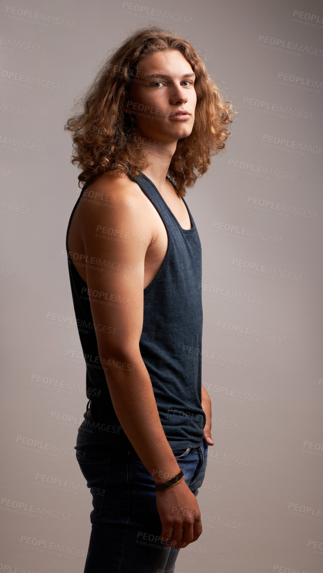 Buy stock photo Man, model and fashion in portrait in a studio with casual clothes, curly hairstyle and cool style. Summer outfit, trendy and stylish with serious face, young with hair and gen z on grey background