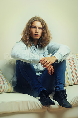 Buy stock photo Man, relax on sofa and fashion model in portrait with casual clothes, curly hairstyle and cool style. Denim outfit, trendy and stylish with serious face, relax in a house with hair, young and gen z