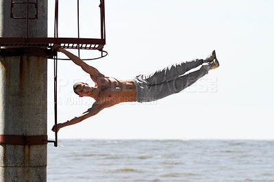 Buy stock photo A muscular young man practicing parkour at the beach