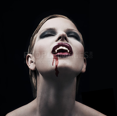 Buy stock photo Blood, woman and vampire with fantasy, fangs and lady against a dark studio background. Female person, supernatural being and girl mystic, aesthetic and monster with creativity, demon and character