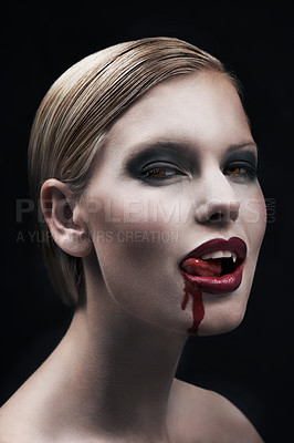 Buy stock photo Portrait, blood and a woman vampire in studio on a dark background for halloween or cosplay. Fantasy, horror or scary with an attractive young female monster posing as an evil and feminine creature
