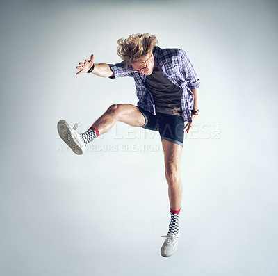 Buy stock photo Man, hipster and fashion jump in studio dancing isolated, grey background or mockup space. Male person, glasses and funky socks or leap crazy energy or fun cool style, comedy or activity expression