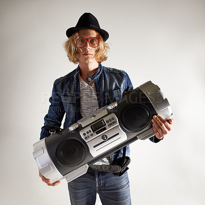 Buy stock photo Boombox, fashion and portrait of a man in studio with music, radio or audio sound. Serious model person on grey background with denim outfit, glasses and hipster hat or retro style to listen to song