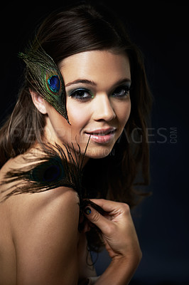 Buy stock photo A gorgeous young woman with dramatic eye makeup holding a peacock feather