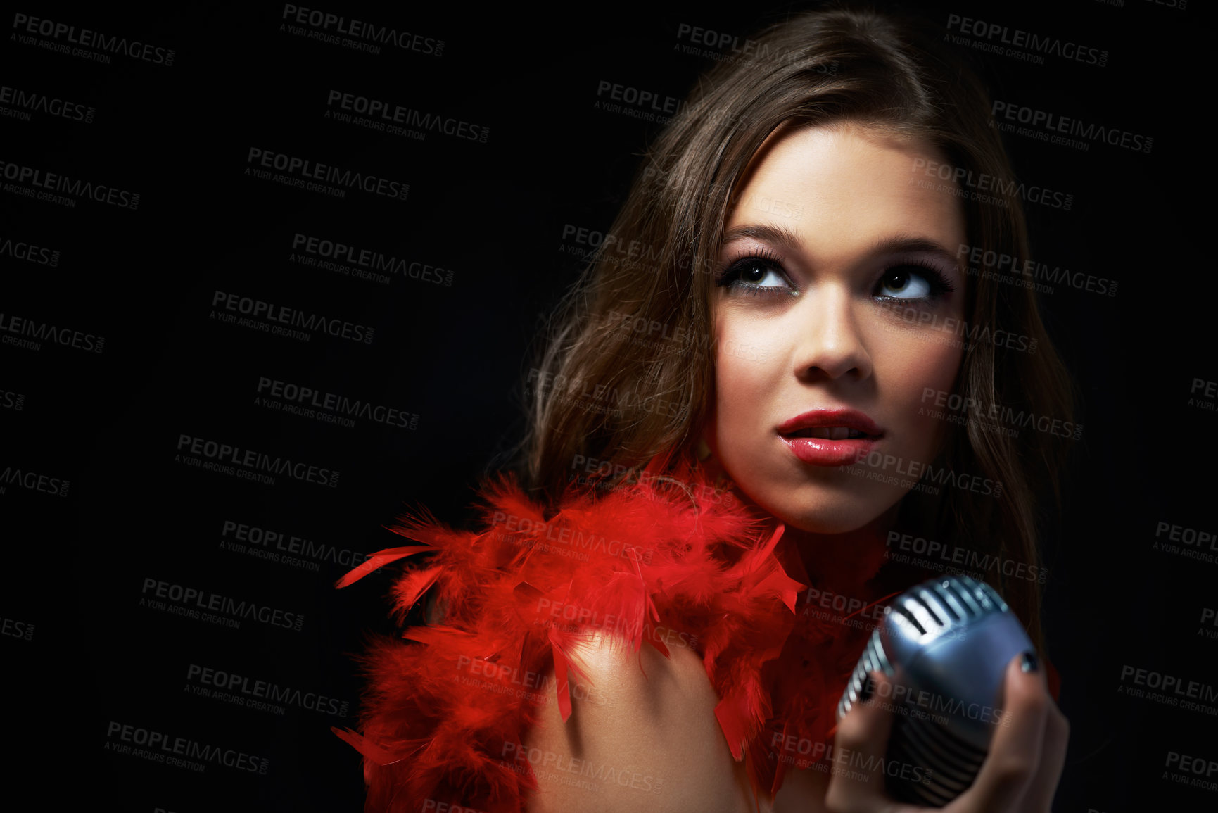 Buy stock photo Shot of an attractive young singer holding an old-fashioned microphone