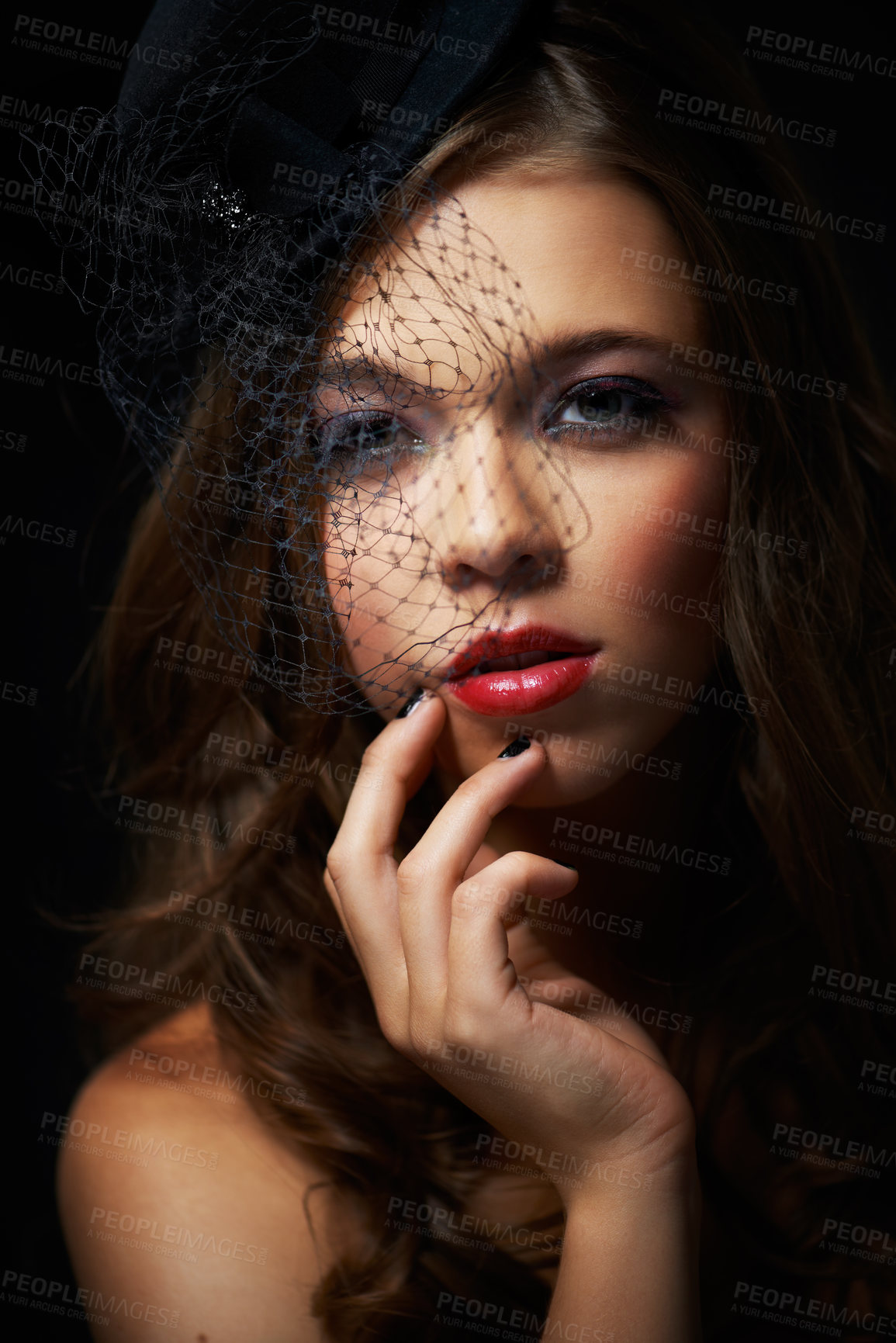 Buy stock photo A dramatically made-up young woman wearing a stylish hat with a netted veil