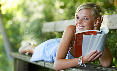 Buy stock photo Smile, relax and book with woman on park bench for literature, summer and happiness. Calm, nature and peace with young female person reading in countryside for knowledge, learning and studying