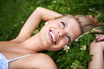 Buy stock photo Spring, happy and relax with woman on grass in nature for calm, smile and peace. Smile, flowers and field with face of female person lying in countryside meadow for summer, vacation and wellness