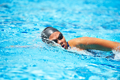 Buy stock photo Female swimmer making her way through a swimming pool stroke by stroke