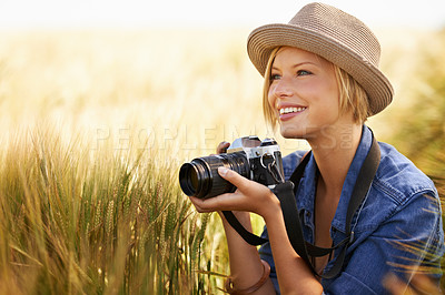 Buy stock photo Field, smile and woman with a camera, photographer and sunshine with tourism, travelling and nature. Person, photography or girl with summer, thinking or countryside with picture, freedom or creative