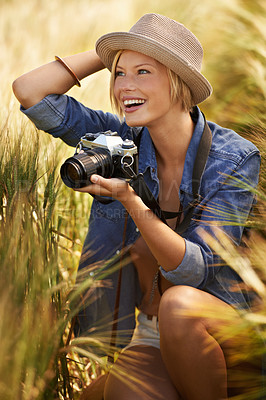 Buy stock photo Field, excited or woman with a camera, photographer or sunshine with tourism, travelling or nature. Person, photography or girl with summer, happiness or countryside with picture, outdoor or creative