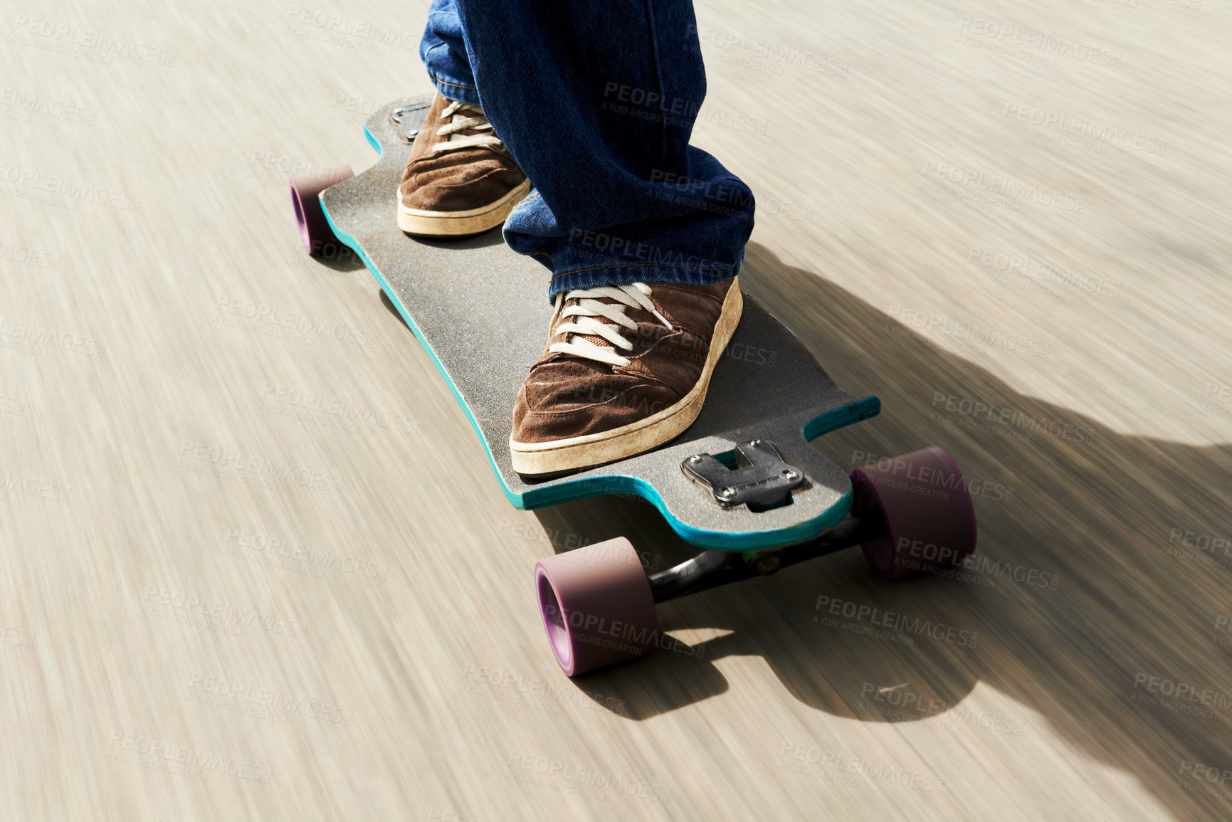 Buy stock photo Cropped shot of a man riding a skateboard at high speed
