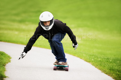 Buy stock photo Shot of a skateboarder making his way down a lane on his board