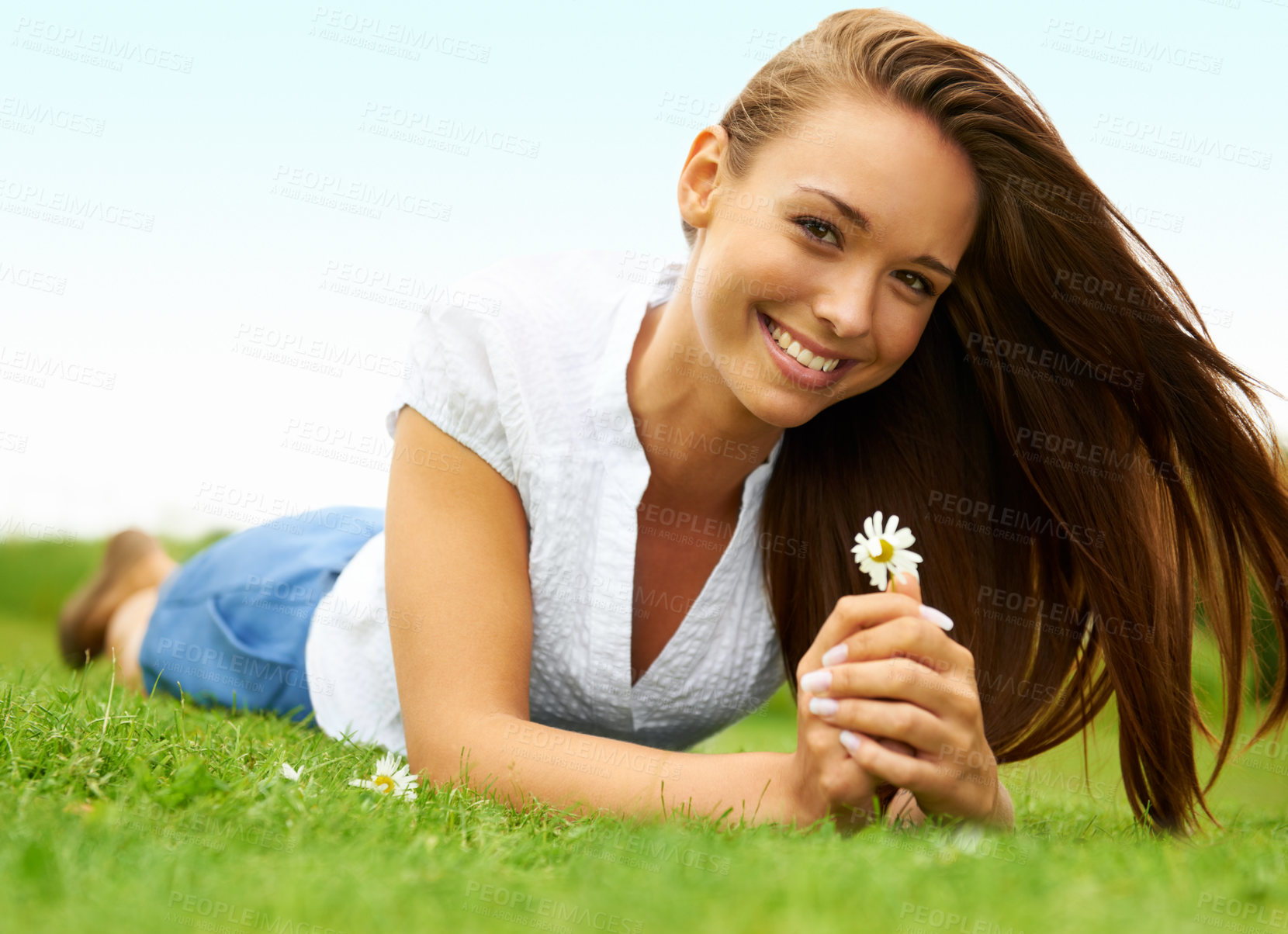 Buy stock photo Portrait, smile and woman with daisy on grass, lying down on field and enjoying spring on vacation outdoor. Happy, flower plant and beauty of female person relaxing, smiling and having fun in nature.