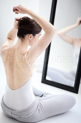 Buy stock photo Female ballerina doing her hair by a mirror in a studio before a dance class, performance or concert. Art, creative and back of young ballet dancer getting ready for classical dancing in her room.