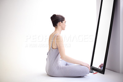 Buy stock photo Young ballerina sitting in front of a mirror and looking at herself