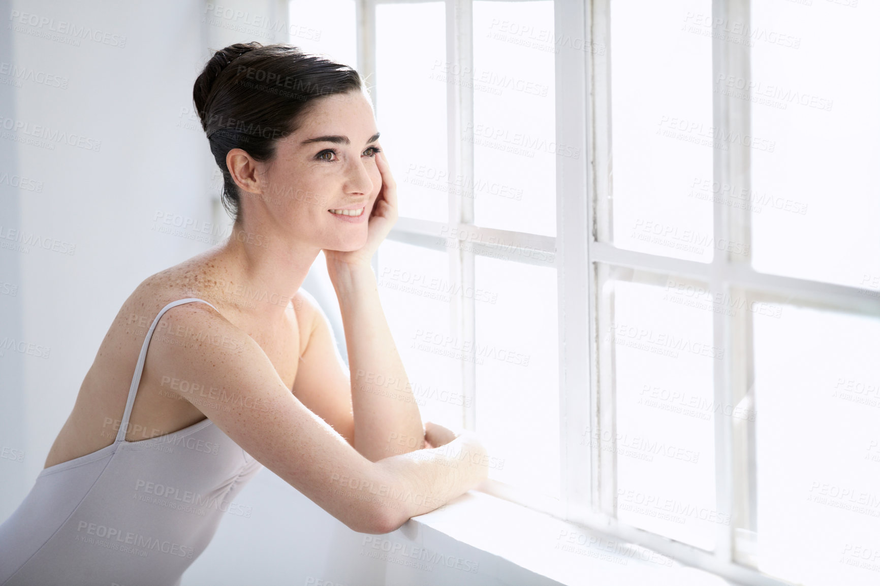 Buy stock photo Smiling young ballerina looking out of a window