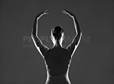 Buy stock photo Silhouette of a young ballerina dancing against a dark background
