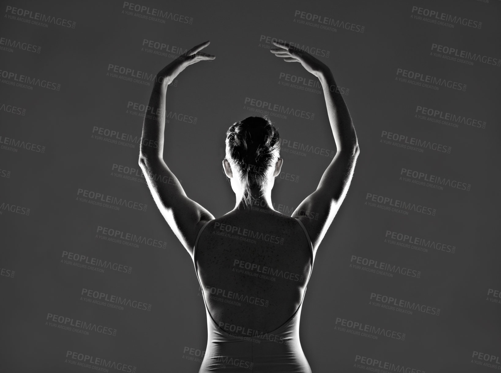 Buy stock photo Silhouette of a young ballerina dancing against a dark background