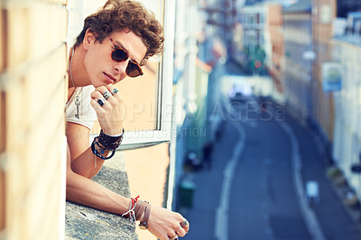 Buy stock photo Portrait, fashion or apartment window with a man looking out at a city street in sunglasses in summer. Face, space or urban style and a confident or cool young model in trendy shades and accessories