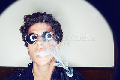 Buy stock photo Portrait of man smoking, sunglasses and grunge fashion with rockstar attitude on white background in spotlight. Cool punk style, creative and smoke, confident face of handsome male model in studio.