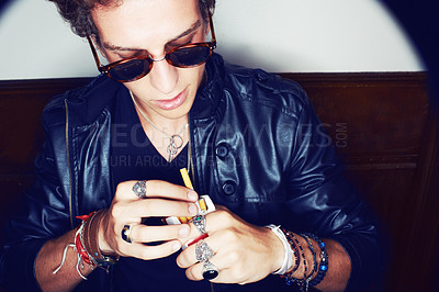 Buy stock photo Man with cigarette in hand, grunge fashion and rockstar attitude on white background in spotlight. Cool punk style, rebel and smoking, confident and handsome male model in studio with sunglasses.