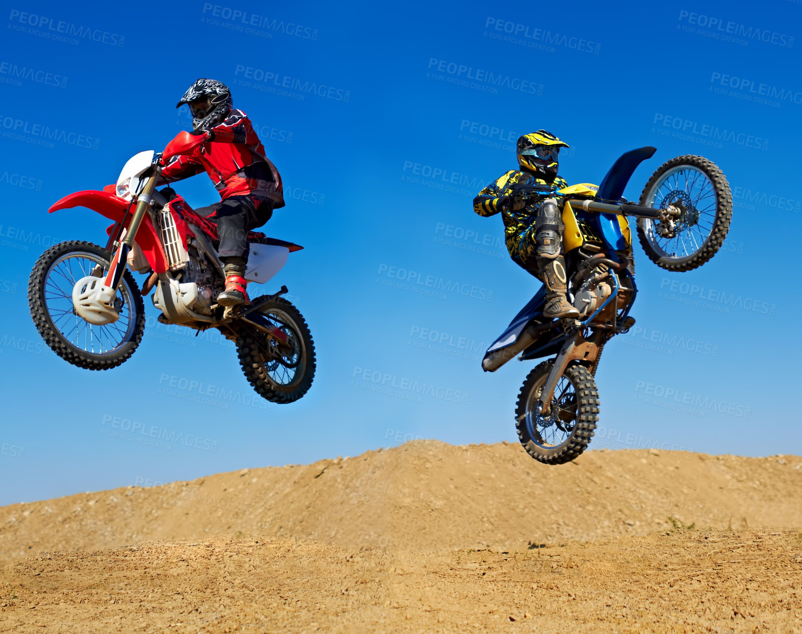 Buy stock photo Action shot of two dirt bikers jumping in different directions