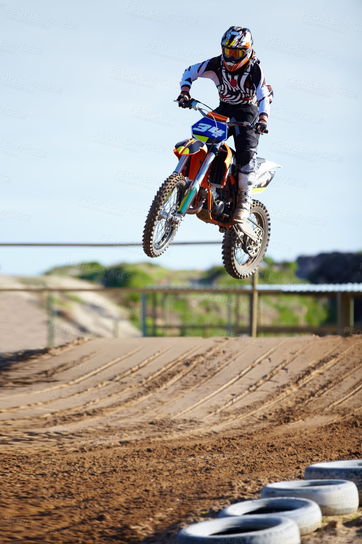Buy stock photo Person, motorcycle or bike jump on race track as professional in action competition, fearless or dust path. Rider, off road transportation for fast speed adventure or rally, extreme sport or gear