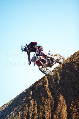 Buy stock photo Man, motorcycle and dirt bike on hill professional rider in action danger competition, fearless or race. Male person, transportation or fast mountain adventure or blue sky, rally challenge or driving