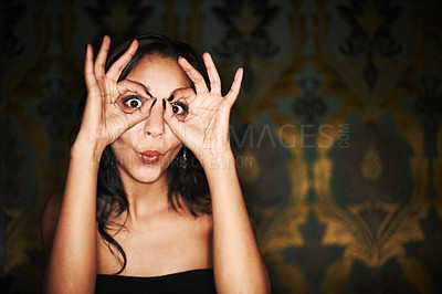 Buy stock photo Woman, hands and ok or sign on face at club, crazy and silly or goofy, energy and funny at night. Female person, dark and comedy or humor, eyes and emoji or icon, posing and agree with yes review
