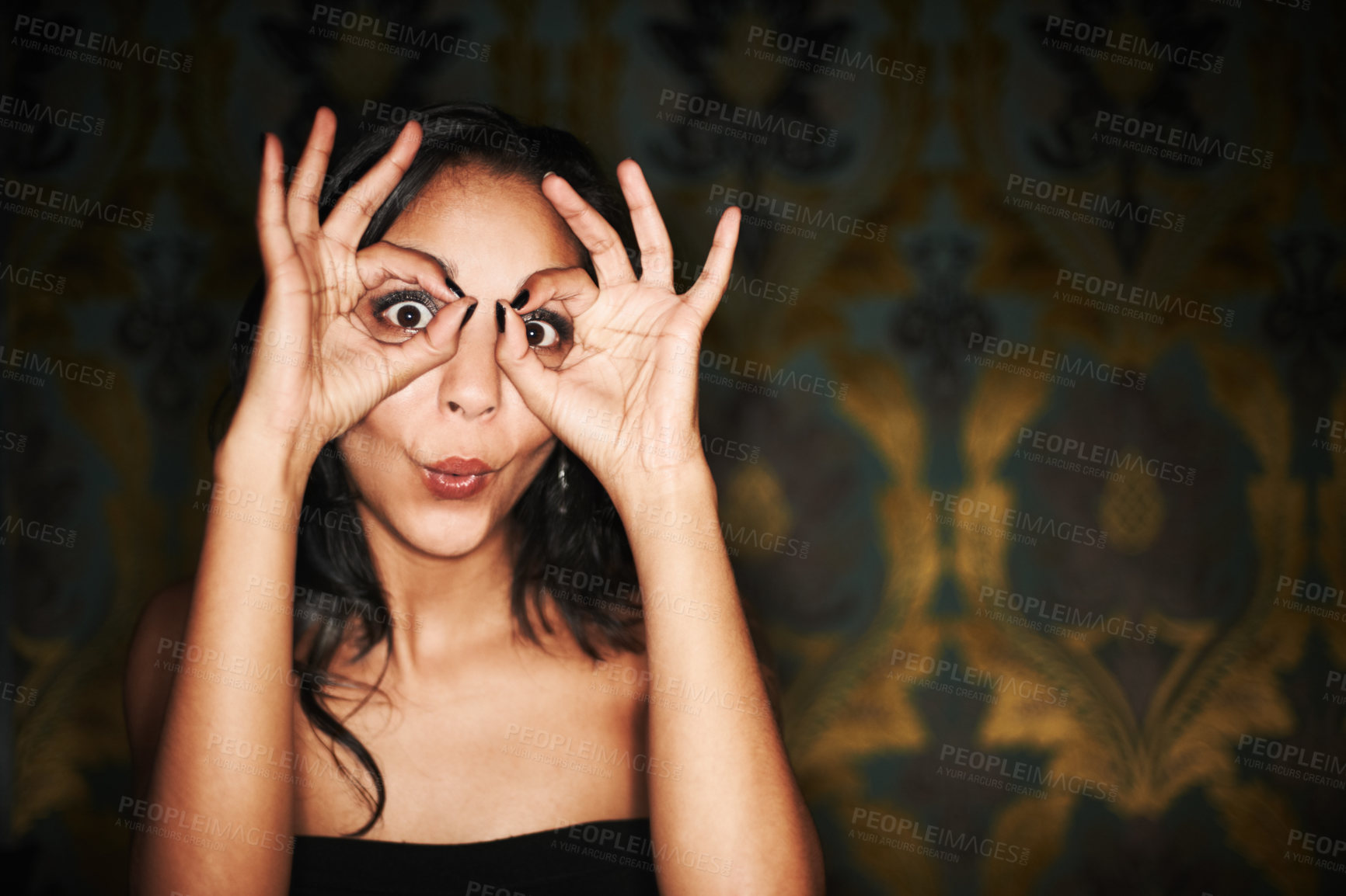 Buy stock photo Woman, hands and ok or sign on face at club, crazy and silly or goofy, energy and funny at night. Female person, dark and comedy or humor, eyes and emoji or icon, posing and agree with yes review