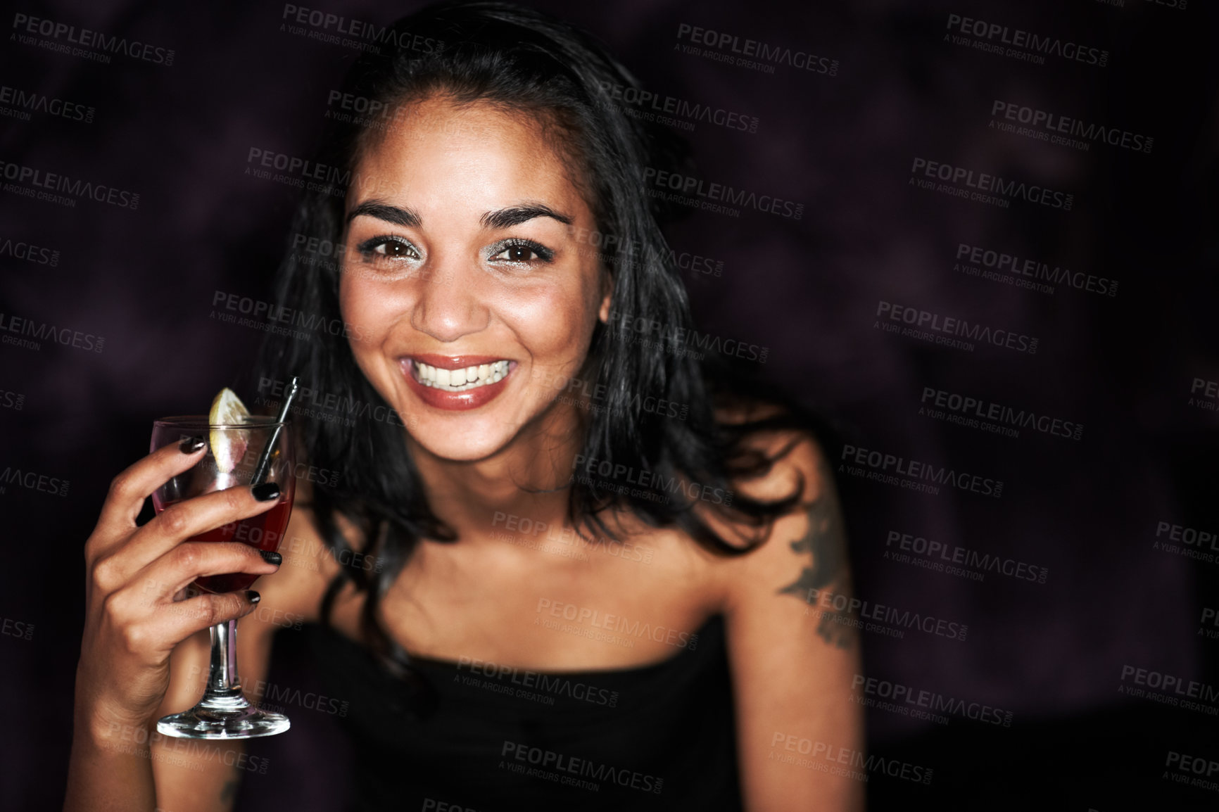 Buy stock photo A pretty young girl enjoying a cocktail alongside copyspace against a dark background