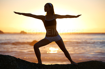 Buy stock photo Woman, sunset and fitness on beach with warrior pose for stretching of muscles at sunrise. Person, shadow and balance for zen, healthy and mindset with movement with relaxing with outdoor yoga
