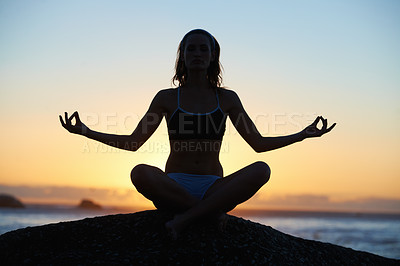 Buy stock photo Silhouette of a young woman doing a yoga pose against an orange sunset
