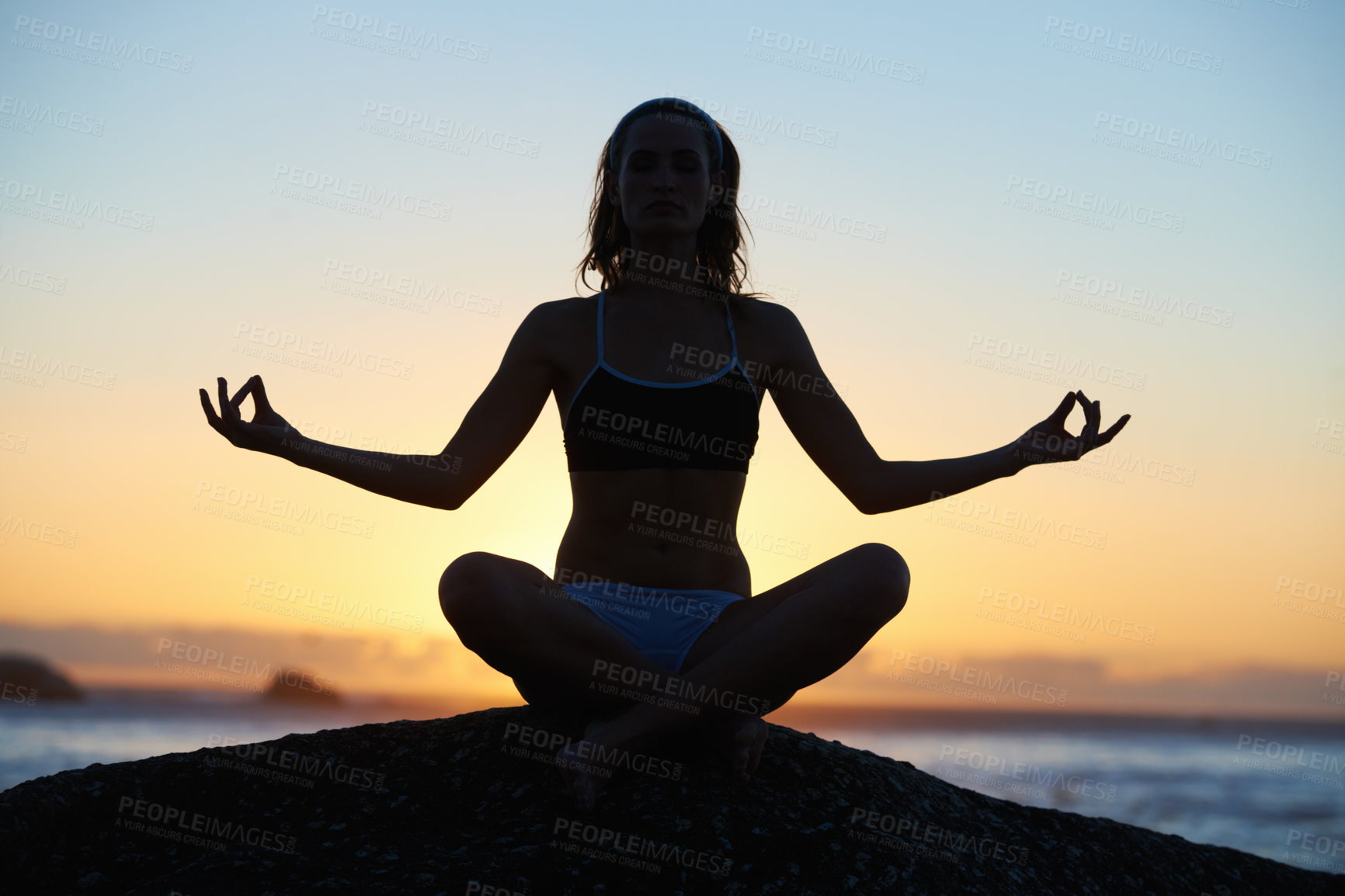 Buy stock photo Silhouette of a young woman doing a yoga pose against an orange sunset