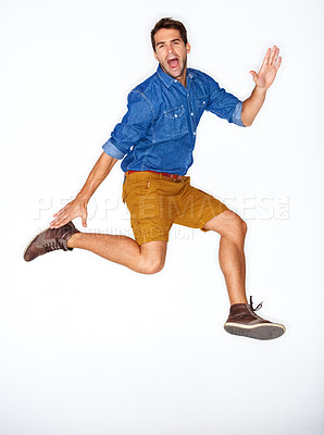 Buy stock photo Portrait, fashion and energy with a man jumping in studio on a white background for trendy hipster fashion. Success, winner and leap for motivation with a young model shouting in a clothes outfit