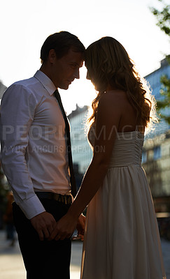 Buy stock photo Couple holding hands, love and content outdoor with silhouette, sunset and forehead touch while in city. Man with woman, trust and respect with commitment, marriage and care, partnership and peace